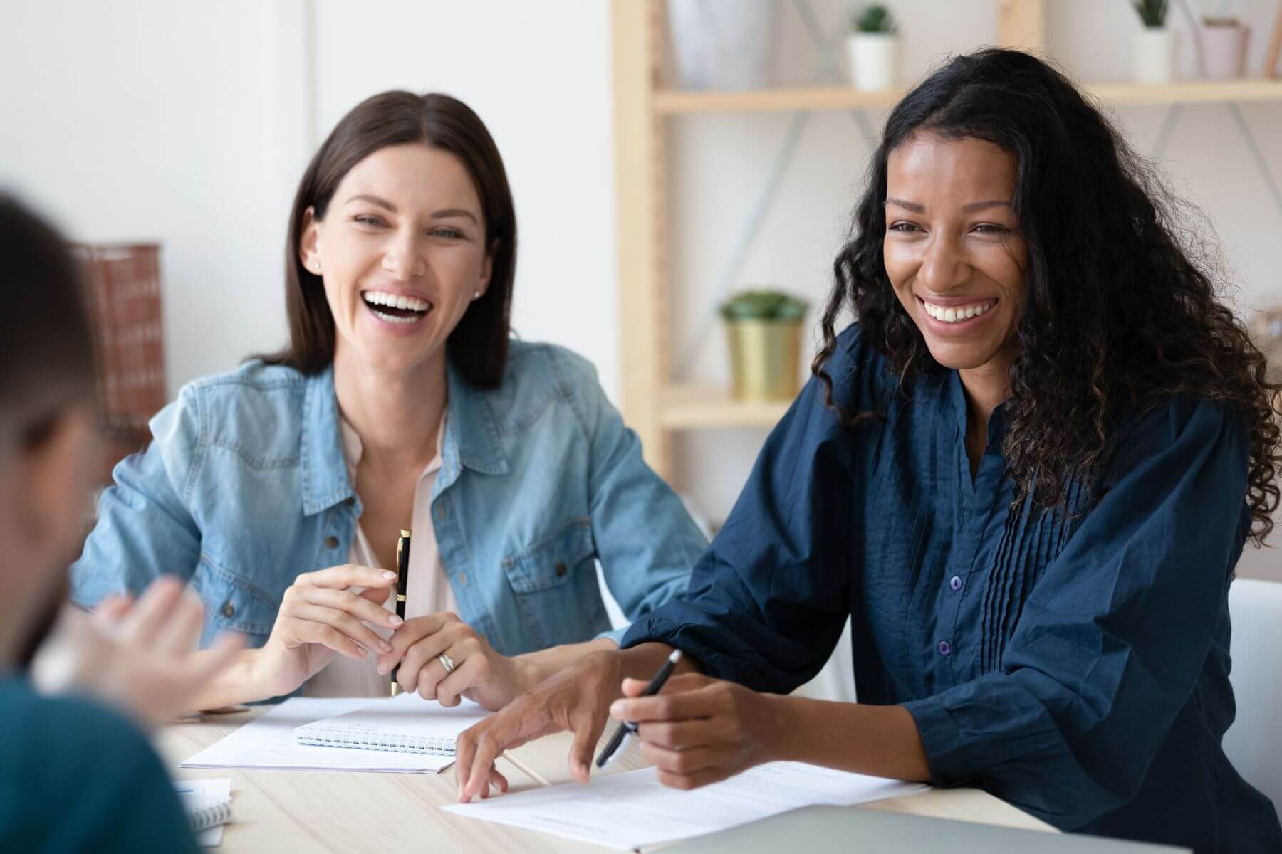 happy employees sitting around a table smiling