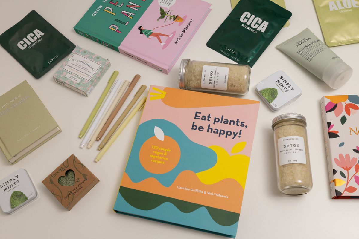green books, stationery, beauty products themed around q3 on a desk