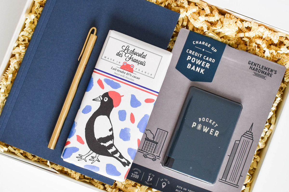 notebook, pen, charger, chocolate in a gift box