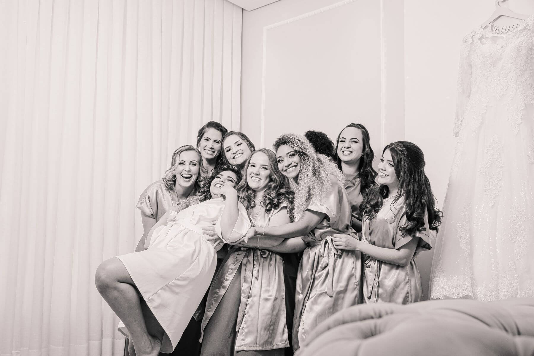 black and white picture of bride and her bridesmaid hugging 