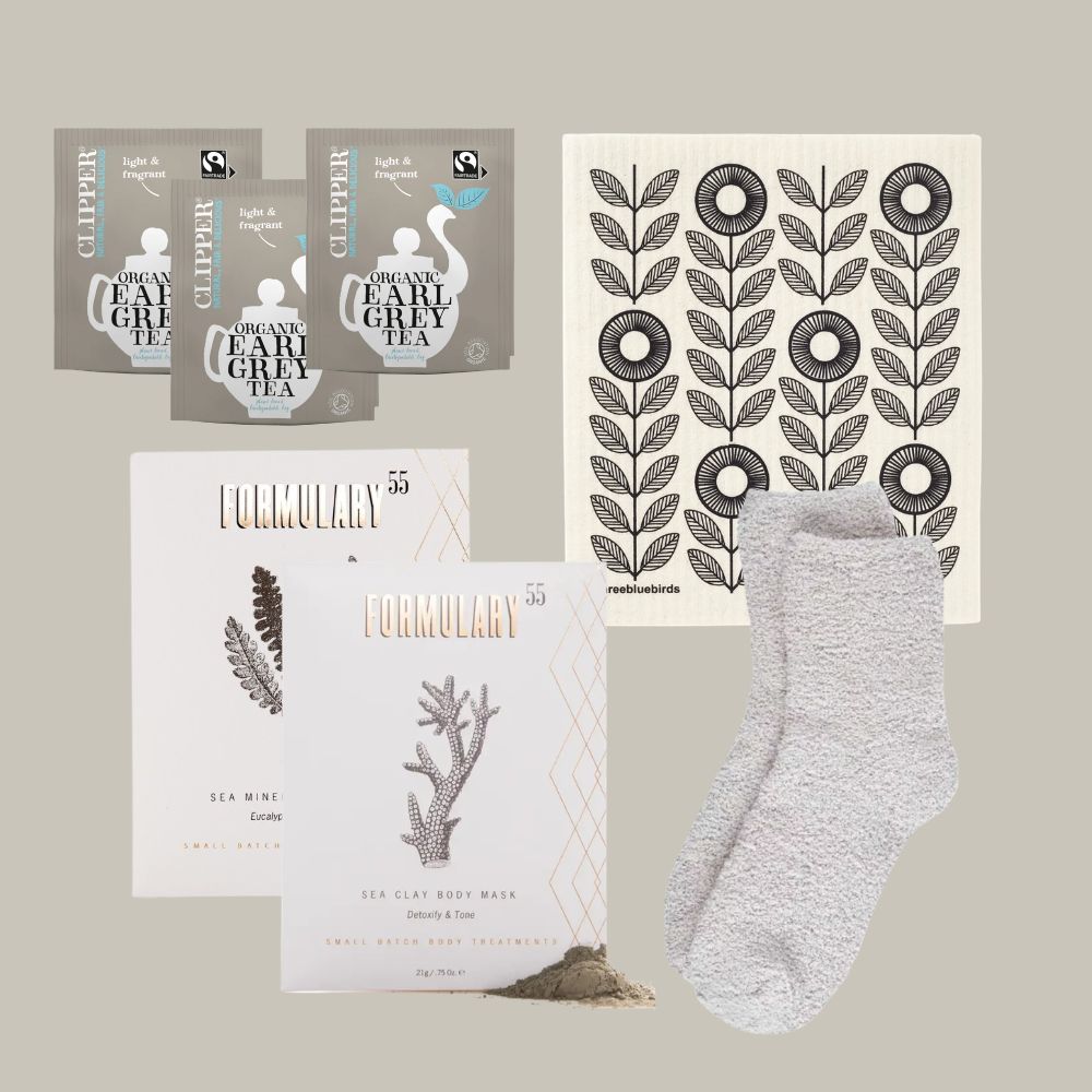 Tea packages, body mask, and socks on a neutral background