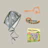 Baby hat with star pattern, wooden rattle, teething ring, and 'Baby Elephant' book on a beige background