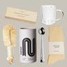 Collection of items including a mug, tea canister, socks, and cleaning brush on a neutral background